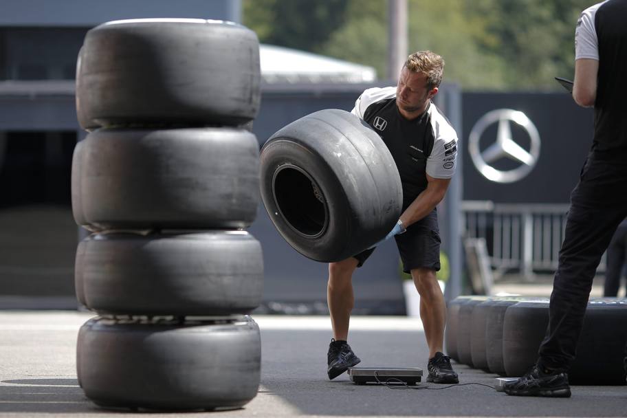 Preparativi per il Gp di Belgio di Formula Uno, a Francorchamps: un meccanico McLaren sistema le gomme nel paddock. (Epa)